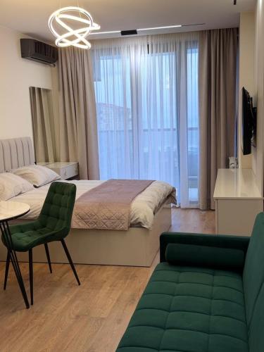a bedroom with a bed and a table and a couch at next apartment lux in Batumi