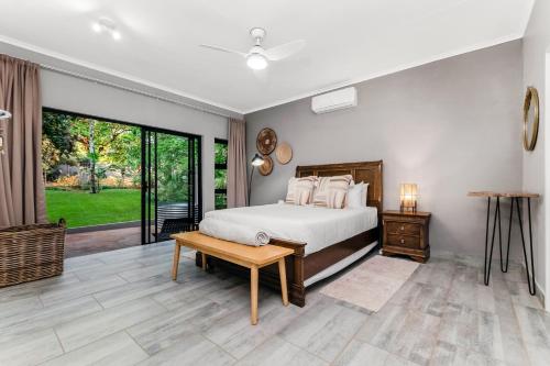 a bedroom with a bed and a large window at Honeysuckle in Tzaneen