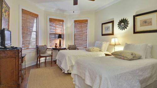 a bedroom with two beds and a tv and windows at Amelia Home by AvantStay In Historic Old Town w Pool in Key West