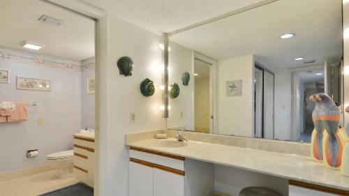 a bathroom with a sink and a large mirror at Atlantic Paradise by AvantStay Great Location w Balcony Outdoor Dining Shared Pool Hot Tub in Key West