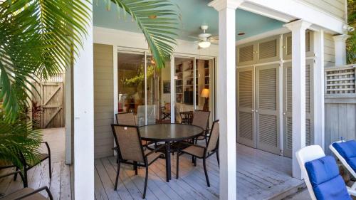a porch with a table and chairs on a house at Tropical Dreaming by AvantStay 4 BLKS to Beach Private Pool in Key West