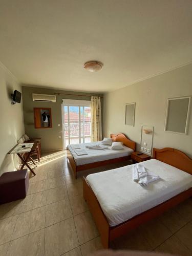 a hotel room with two beds and a window at Villa Maria in Sarti