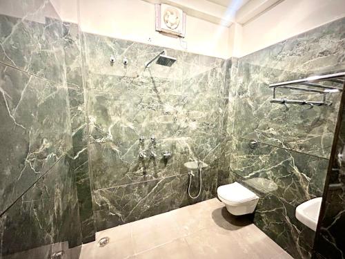 a bathroom with a shower and a toilet in it at Markandey Bhavan in Deoghar