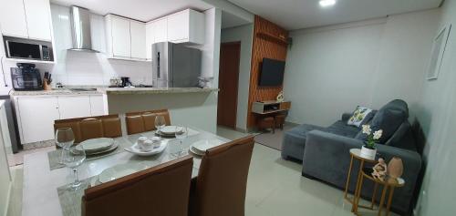 a kitchen and living room with a table and a couch at Praia da Graciosa Apartamento 2 quartos in Palmas