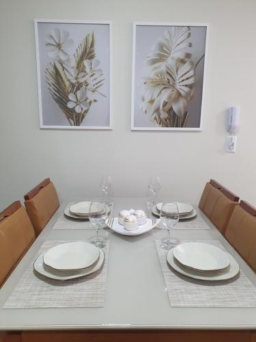 a dining room table with plates and wine glasses at Praia da Graciosa Apartamento 2 quartos in Palmas