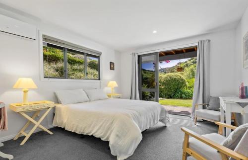 a white bedroom with a bed and a window at Nelson Escape in Nelson