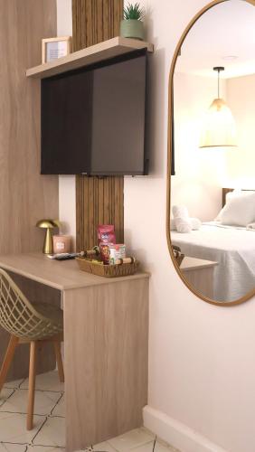 a mirror in a bedroom with a desk and a bed at Margarita 93 in Barranquilla