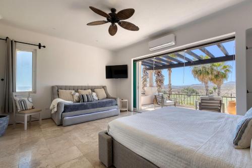 a bedroom with a bed and a couch and a window at The Fairway Villa in San José del Cabo