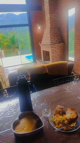 a table with a plate of food and a bottle of sauce at Serra mineira in Resende