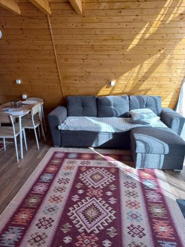 a living room with a blue couch and a table at Cabanele Avoca in Avrig
