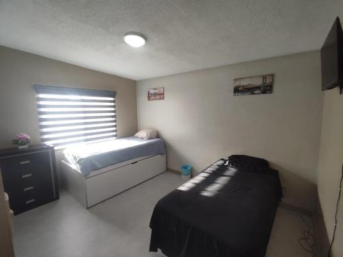 a small bedroom with a bed and a window at Floresta in Manuel F. Martínez