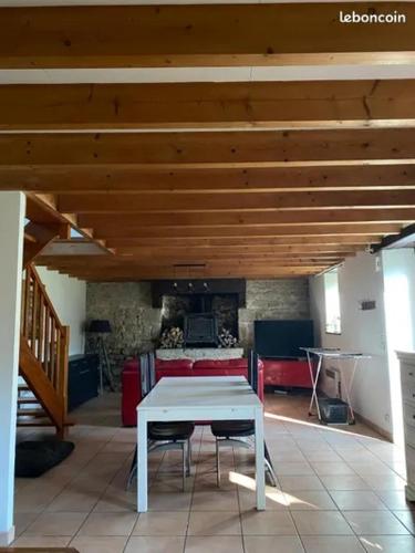 a white table and chairs in a room with a fireplace at Charmant penty pour un séjour calme et reposant in Ergué-Gabéric