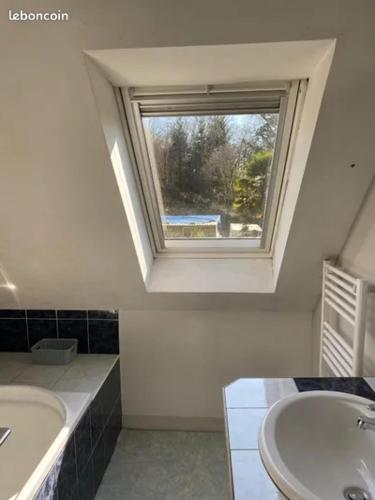a bathroom with a sink and a window at Charmant penty pour un séjour calme et reposant in Ergué-Gabéric