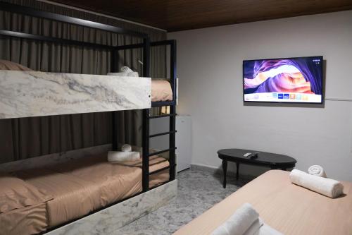 Una habitación con dos literas y un televisor de pantalla plana. en Villa 2VB, en Shkodër