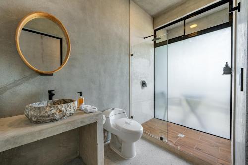 a bathroom with a toilet and a mirror at Nelblu Flamingo Suites in Playa Flamingo