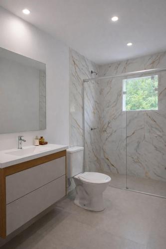 a bathroom with a toilet and a sink and a shower at M&M Pousada in Petrópolis