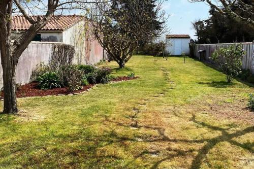 an empty yard with a fence and a yard with trees at La Villa de la Digue in Saint-Clément-des-Baleines