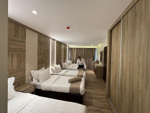 a man sitting in a hotel room with two beds at mass paradise2 in Aqaba