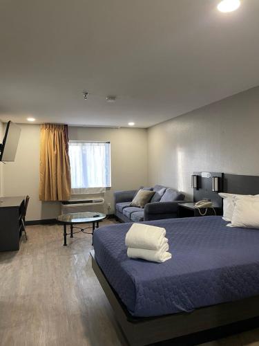 a room with two beds and a couch and a living room at Pinetop Studio Suites in Pinetop-Lakeside