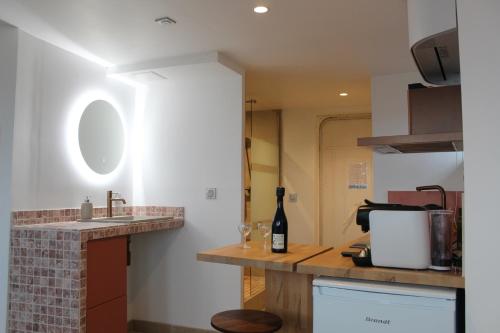a kitchen with a sink and a counter with a bottle of wine at La Tour'angelle in Saint-Étienne-de-Chigny