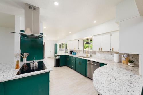 a large kitchen with green cabinets and a counter top at 4 Bed sleeps 12 -Sea world-Six Flags-Down Town - Emerald Oasis in San Antonio