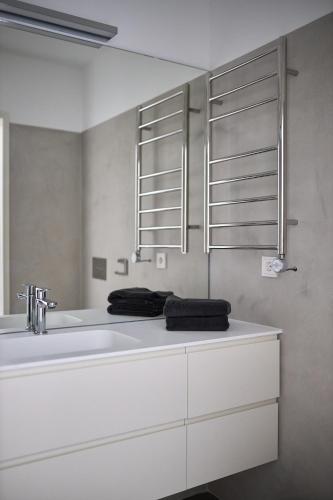 a white bathroom with a sink and a mirror at Casa Calmavista in Paços de Gaiolo