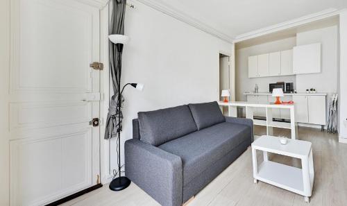 un soggiorno con un divano blu e una cucina di Paris Pompidou a Parigi