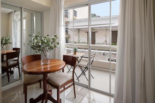 une salle à manger avec une table, des chaises et une fenêtre dans l'établissement Hodelpa Caribe Colonial, à Saint-Domingue