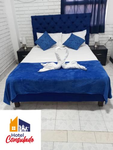 a bedroom with a blue bed with two towels on it at HOTEL CONSULADO Junto al Consulado de Venezuela in Cúcuta