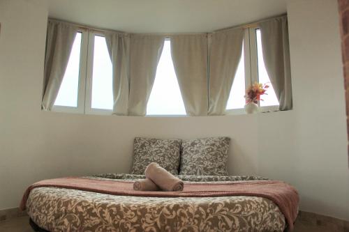 a bed in a bedroom with a window at La Tour'angelle in Saint-Étienne-de-Chigny