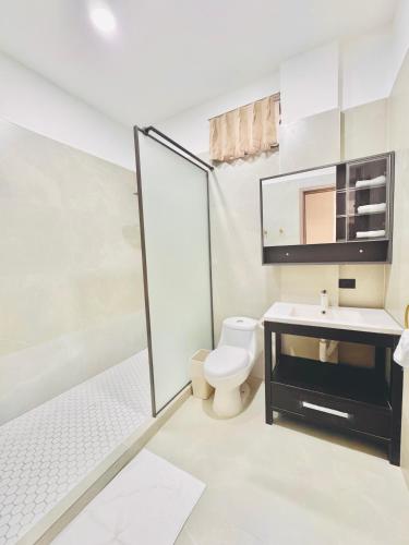 a white bathroom with a toilet and a sink at KOH SAMUI - Apartamentos by Luxury Atitlan in San Pedro La Laguna