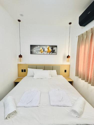 a bedroom with a large white bed with two pillows at KOH SAMUI - Apartamentos by Luxury Atitlan in San Pedro La Laguna
