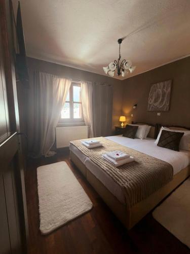 a bedroom with a large bed and a window at ByDoukas Mountain Resort in Palaios Agios Athanasios