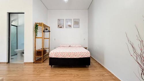 a white room with a bed and a bathroom at Studio 209-AP2 espaço completo ideal para casal in Ubatuba