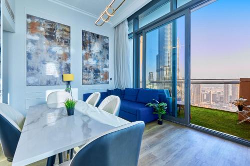 a dining room with a blue couch and a table and chairs at Burj Khalifa View Apartments, Burj Vista Tower - Downtown in Dubai