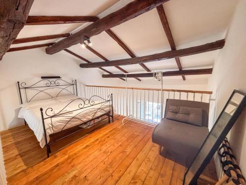 a bedroom with a bed and a chair in it at CAERE RoGi House in Cerveteri
