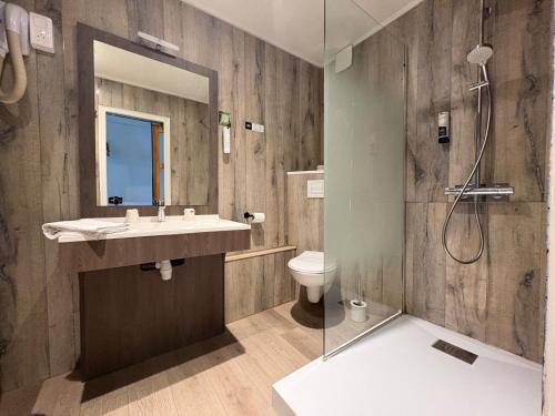 a bathroom with a sink and a toilet and a shower at Logis Hôtel- Restaurant Le Relais Guillaume de Normandy-PARKING GRATUIT--VUE BAIE TERRASSE-CALME-BORNES ELECTRIQUE-LOCAL VELOS SÉCURISÉ in Saint-Valéry-sur-Somme