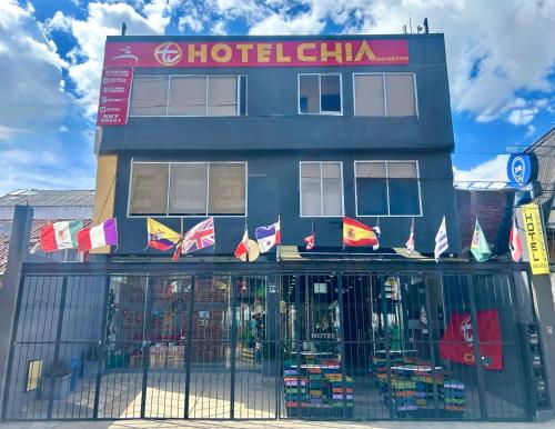a building with flags in front of a store at Tu Hotel Chía in Chía
