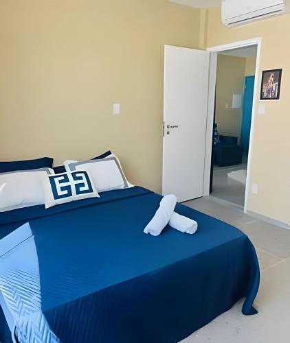 a bedroom with a blue bed with a pillow on it at Flats com Temática Grega na Praia de Aruana | Atena Flats in Aracaju