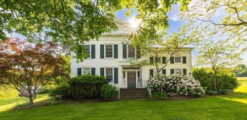 a white house with a lawn and trees at Oak & Anchor Inn in Penn Yan