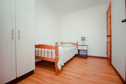 a bedroom with a bed and a wooden floor at Apart Hotel Escala Real in Coquimbo