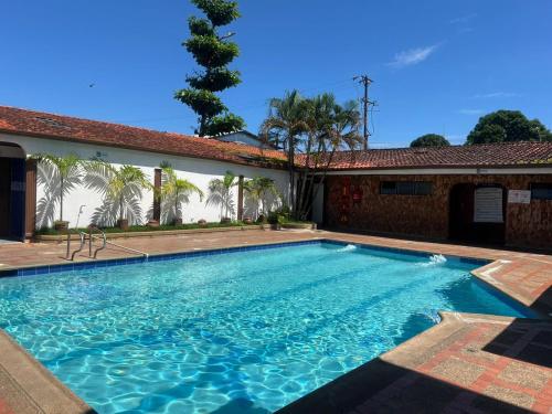 a swimming pool in front of a house at Hotel Santa Barbara in Arauca