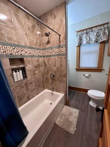a bathroom with a tub and a toilet at Casa Lentini in Omaha