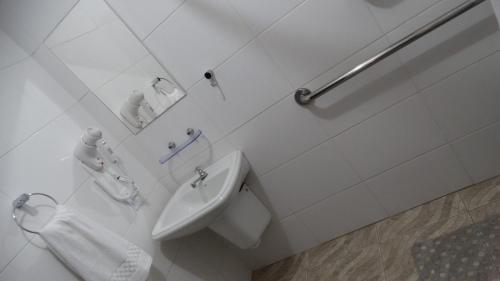 ein weißes Badezimmer mit Waschbecken und Spiegel in der Unterkunft Hotel Niro in Montenegro