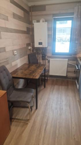 a dining room with a wooden table and chairs at Apartment Ploiesti in Ploieşti
