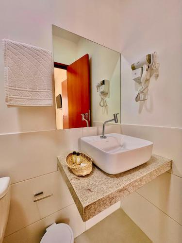 ein Badezimmer mit Waschbecken, Toilette und Spiegel in der Unterkunft Mart's Hotel in Salvador