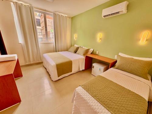 ein Hotelzimmer mit zwei Betten und einem Fenster in der Unterkunft Mart's Hotel in Salvador