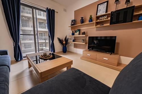 a living room with a couch and a television at Cobalt Canopy a Spacious 2 Bedroom Apartment in St. Paul's Bay