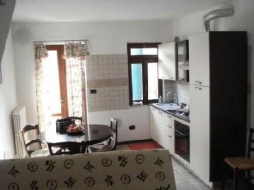 a kitchen with a table and a dining room at Apartment Rote Rose by Interhome in Brusasco