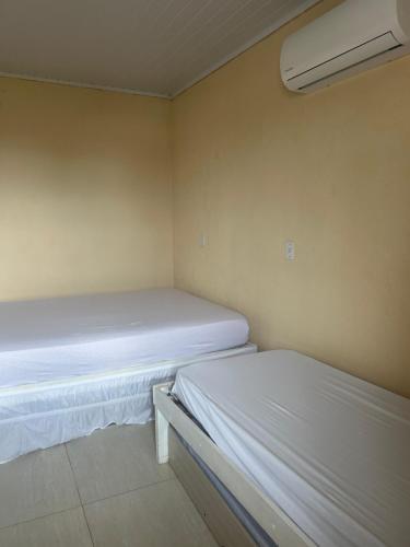 two beds in a small room with a heater at Pousada Mar & Sol in Torres